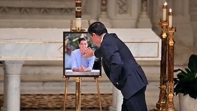 Alex Lucido, a close family friend, touches a portrait of Mr Fraser. AP