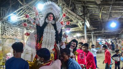Devotees carry a clay idol of Durga at a workshop during the Navratri festival in Allahabad. AFP