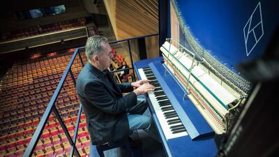 Piano constructor and builder David Klavins plays his new creation, the M470i vertical concert grand piano. AFP
