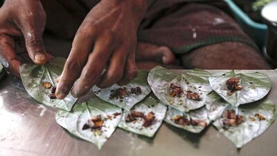 A street vendor prepares betel quids, the digestive chews which are very popular in Myanmar made of small pieces of betel nut wrapped in a betel leaf and spread with lime paste, to sell at a roadside shop in Yangon, Myanmar. Lynn Bo Bo / EPA