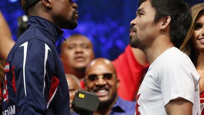 Floyd Mayweather jr, left, and Manny Pacquiao face-off following the official weight-in. John Locher / AP Photo