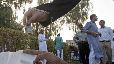 A worshipper gives to a man begging in the Al Baraha section of Deira, Dubai. With the start of the holy month of Ramadan close, authorities have called for a clampdown on begging. Jeff Topping / The National