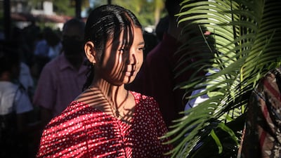 A Catholic faithful holds a palm frond at Balide Church. AFP