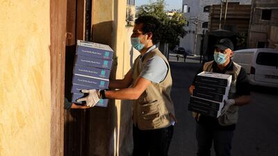 Staff members of "Tkiyet Um Ali" humanitarian services center distribute meals for iftar, or the evening meals, to the homes of poor families for their break fast in the city of Russeifa, during the holy fasting month of Ramadan, amid concerns over the spread of coronavirus disease (COVID-19), in Jordan. REUTERS