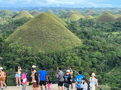 Tourists look out over the Chocolate Hills in Bohol. Photo: David Dunn