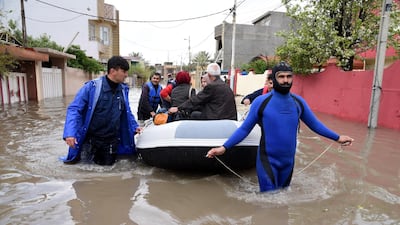 Members of civil defense evacuate Iraqis after their house was flooded due to heavy rains in Mosul city, northern Iraq. EPA