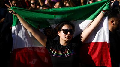 A woman holds a flag, as people protest against the Iranian regime outside Iran's embassy in central London. Reuters