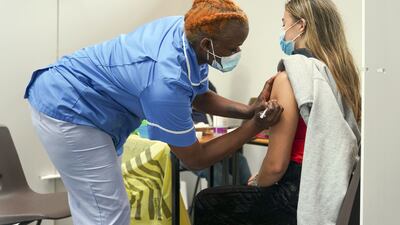 Nurse Marvis Birungi administers a dose of Covid-19 vaccine to a student at a clinic in Oxford, England. PA
