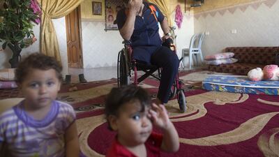 Wael Al Namla at his home in Rafa,Gaza on July 3,2015 with his daughter Abir (center) and his brother’s orphaned son . He lost his the lower part of his right leg during last summer’s war between Israel and the Hamas -controlled Gaza Strip . ‘My life is totally destroyed ‘, said Wael . His wife Azreen lost both her legs, and their son Shareef lost the lower part of his leg . The incident happened on one of the darkest days during the war that has been named ‘Black Friday’ .The family was fleeing on foot trying to reach a safer area when an Israeli rocket attack hit them . Wael’s 11 -year old sister and his brother Yousef and his wife were killed . Heidi Levine for The National