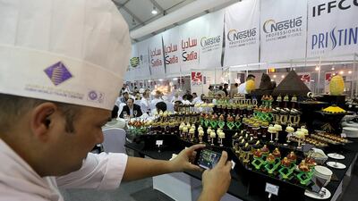 A chef takes a photo of desserts on display at Gulfood. Satish Kumar / The National