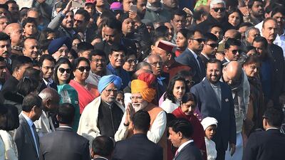 Indian Prime Minister Narendra Modi gestures as he walks past former Indian Prime Minister Manmohan Singh (in blue turban) ahead of the 70th Republic Day parade in New Delhi. AFP