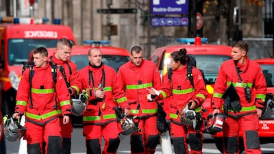 Firefighters walk near Paris prefecture de police. AFP