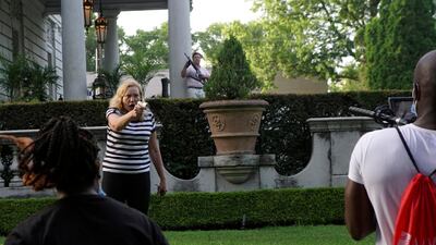 Patricia McCloskey and her husband Mark McCloskey draw their firearms on protestors, including a man who holds a video camera and microphone, as they enter their neighbourhood during a protest against St. Louis Mayor Lyda Krewson, in St. Louis, Missouri, US. Reuters