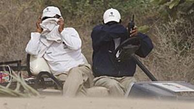 Staff members at the Emirates Golf Club cover up during a sandstorm at the Dubai Ladies Masters Pro-Am yesterday.