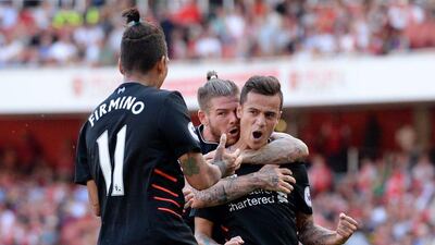 Liverpool's Philippe Coutinho celebrates a goal with Alberto Moreno and Roberto Firmino. Tony O'Brien / Reuters