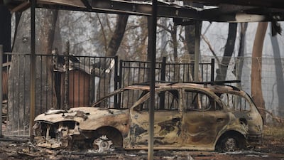 A burnt-out car is seen on property razed by bushfires in Bargo, southwest of Sydney. AFP