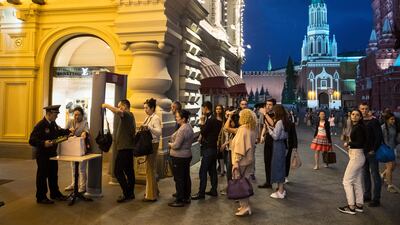 People are checked by security before entering the GUM State Shop in Moscow's Red Square, one of dozens of major buildings, including shopping centres, railways stations, hotels and universities in the Russian capital targeted by telephone hoaxers on September 13, 2017. Pavel Golovkin / AP Photo
