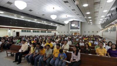 Mourners gather at St Joseph's Cathedral at a mass for the former president of the Philippines.