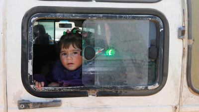 A child looks out of a window as Syrian refugees prepare to return to Syria from the Lebanese border town of Arsal, Lebanon, on June 28, 2018. Mohamed Azakir / Reuters