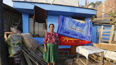 Victoria Ochante, 67, in front of her new home in Gosen City. Until two years ago Ochante was a garbage picker, combing Lima’s trash for items to sell to recyclers. Now with her savings and her daughter’s help she retired and spends her time taking care of her grandchildren. Mariana Bazo / Reuters
