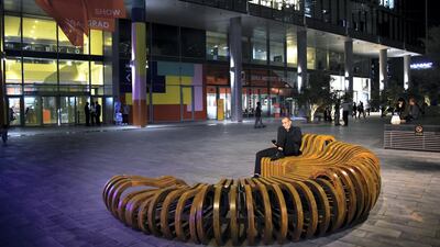 A man sits outside during Dubai Design Week. Shruti Jain / The National