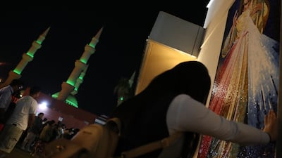 With Mary the mother of Jesus mosque in the background, a worshiper prays in front of a picture of Jesus while attending Christmas Eve prayers at St. Joseph's Cathedral Catholic Church in Abu Dhabi, United Arab Emirates. EPA