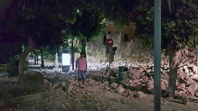 A man walks near a damaged building in Kos. Kalymnos-news.gr via AP