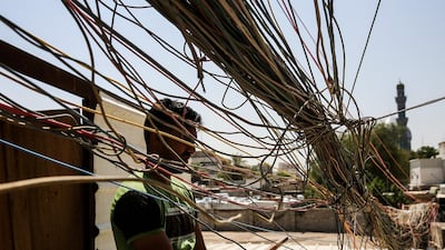 A man checks the wiring on electric cables reaching out to homes in Saadoun Street in the Iraqi capital Baghdad. AFP