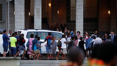 People wave flags next to a vehicle carrying Britain’s Prince Harry and Meghan. Reuters
