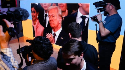 Visitors watch a broadcast of Donald Trump's inauguration ceremony at Ukraine House pavilion at the World Economic Forum in Davos. Bloomberg
