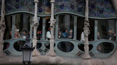 Tourists look out from Antoni Gaudí's Casa Batllo building at a Pro independence demonstration march in support of Catalonian politicians who have been jailed on charges of sedition and the detention of deposed leader of Catalonia's pro-independence party Carles Puigdemont in Barcelona, Spain, on March 25, 2018. Manu Fernandez / AP Photo