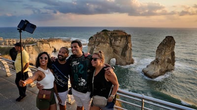 Tourists take a selfie in front of the Rawcheh Sea Rock as the sun sets over the Mediterranean Sea in Beirut, Lebanon. AP