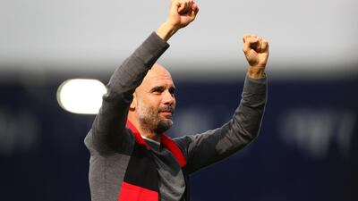 Pep Guardiola, manager of Manchester City, celebrates whilst wearing a black and red scarf in memory of former club secretary Bernard Halford. Getty Images
