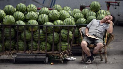 A watermelon vendor snoozes as he waits for customers at a market in Taiyuan, Shanxi province. Jon Woo / Reuters
