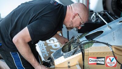 A mechanic from the Arrows A3 team fits the front scoop of their race car