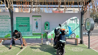 A man recharges his Ola electric scooter in New Delhi, India. Governments in wealthy countries should look for ways to support EV adoption in emerging nations. Reuters