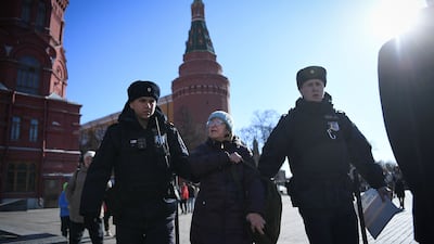 Police officers in Moscow detain a woman as she protests against Russia's invasion of Ukraine. AFP