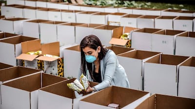 A volunteer prepares boxes with food and other basic goods at the Montessori School grounds in Nairobi, Kenya. The boxes will be delivered in the slums to people affected by the measures adopted by the Kenyan Government to stop the spread of Covid-19. Luis Tato / AFP