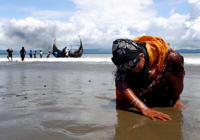 An exhausted Rohingya refugee woman touches the shore after crossing the Bangladesh-Myanmar border by boat through the Bay of Bengal, in Shah Porir Dwip, Bangladesh September 11, 2017. Reuters