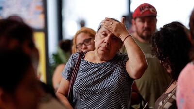 In this September 1, 2017 file photo, a woman waits with others in line for donated goods from a makeshift distribution centre set up among the cubicles of an office in Pasadena, Texas. Gregory Bull / The Associated Press