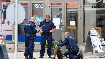 The suspect lies on the ground surrounded by police officers at the Market Square where several people were stabbed, in Turku, Finland. Courtesy Kirsi Kanerva /Handout via Reuters.