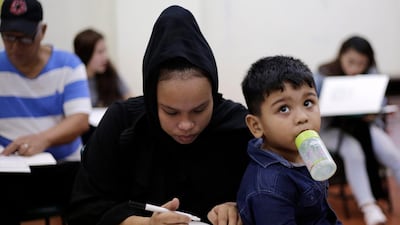 A Filipino Muslim mother fills out her ballot at an elementary school turned into a voting precinct in Manila, Philippines. EPA