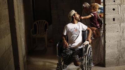 The wife of Mohammed Abed Al Dayem carries her daughter as she feeds her father chocolate.