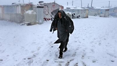 A man walks through the snow. Hussein Malla / AP Photo