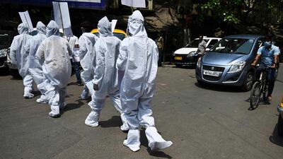 Protesters wearing hazmat suits demonstrate near the Election Commission office in Kolkata on April 7, 2021. They demand that the ongoing state legislative election and campaign rallies be put on hold because of the rise in coronavirus cases. AFP