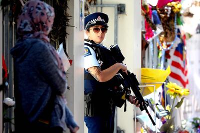 An armed police officer stands guard outside the Al Noor mosque during Friday prayers in Christchurch. Sanka Vidanagama / AFP