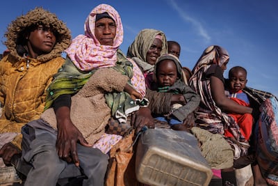 Sudanese refugees ride back to their temporary shelter after receiving food aid at the refugee camp in Oure Cassoni, Chad in February. Getty Images