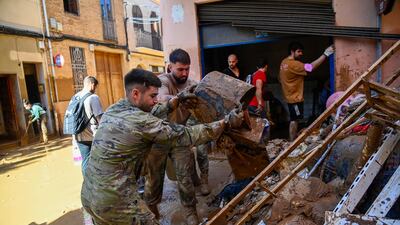 Members of the military work to clear mud and debris in the town of Catarroja on Saturday. AFP