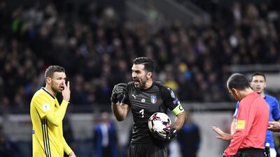 Referee Cuneyt Cakir, right, tries calming Italy goalkeeper Gianluigi Buffon, centre, and Sweden forward Marcus Berg in the first leg. Jonathan Nackstrand / AFP