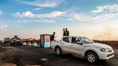 Members of the Syrian Kurdish Asayish internal security forces ride in the back of a pickup truck during a joint patrol with Russian military police vehicles in Amuda. AFP